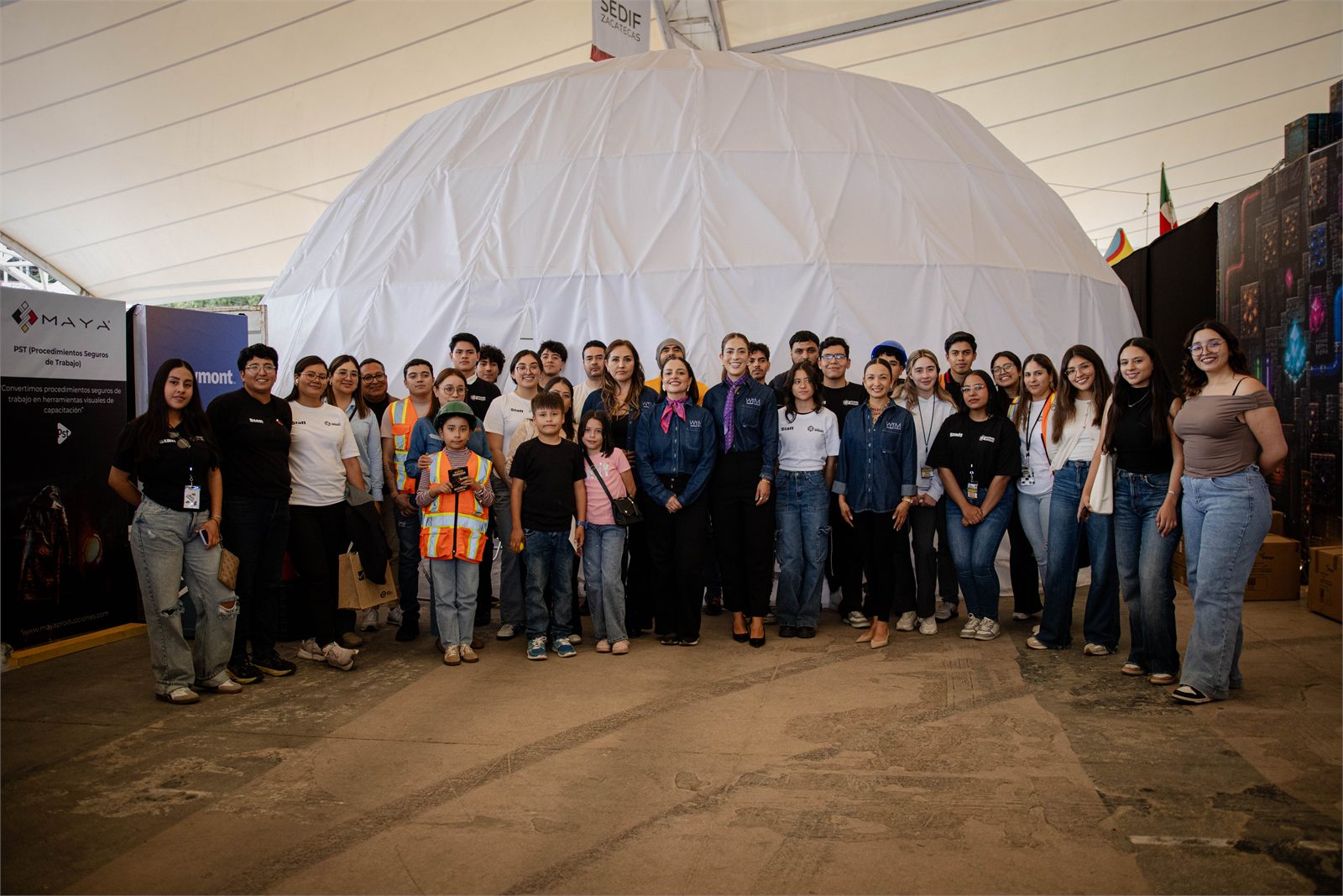 Foto de grupo de asistentes y ponentes de Mujeres WIM frente al domo de la FENAZA