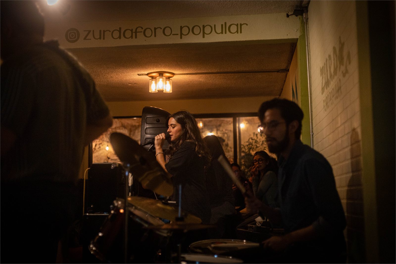 Concierto en Zurda Foro Popular: la banda tocando en un espacio íntimo con luz cálida
