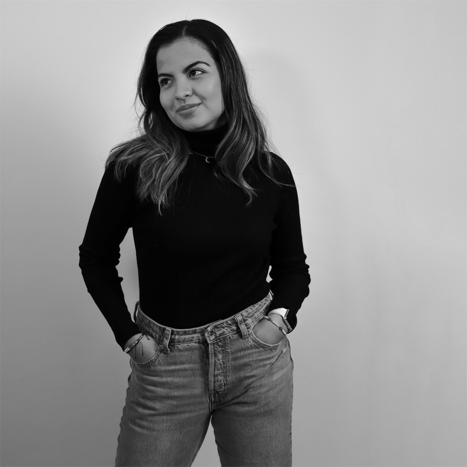 Retrato de estudio en blanco y negro, de pie con las manos en los bolsillos